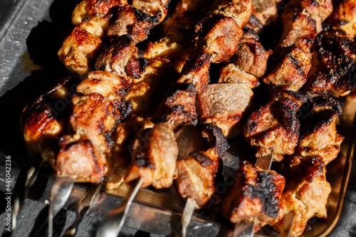 grilled meat on the grill. shish kebab on the grill. Grilled meat skewers, shish kebab on black background, banner