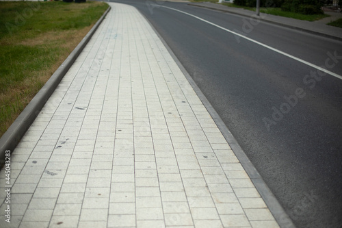 White tile sidewalk. Walking path in the city.