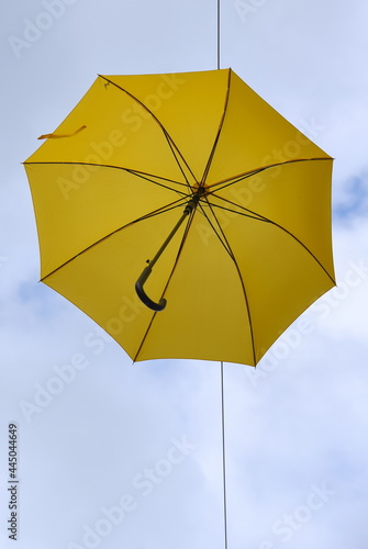Strahlend gelber Regenschirm vor blauem Himmel