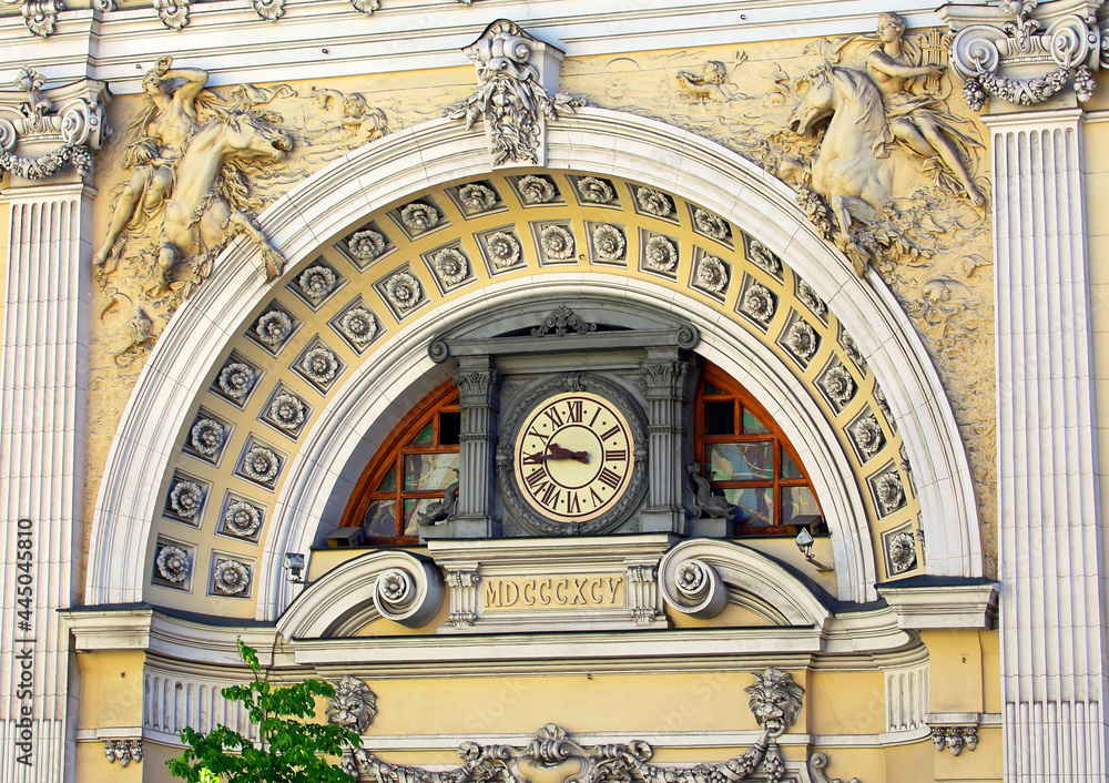 Front of a building with a clock and stucco