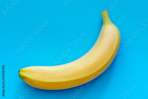 Close up one single banana with deep sky blue colour background, Nature fresh yellow banana fruit with blue pastel backdrop.