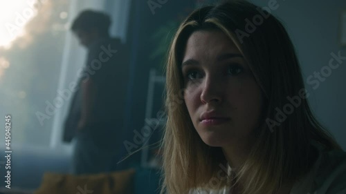Young sad woman portrait. Emotional despairing man waving his hands near window in living room, feeling anger and stress, bad mood. Scandals, hysteria and quarrels in family, relationship crisis.