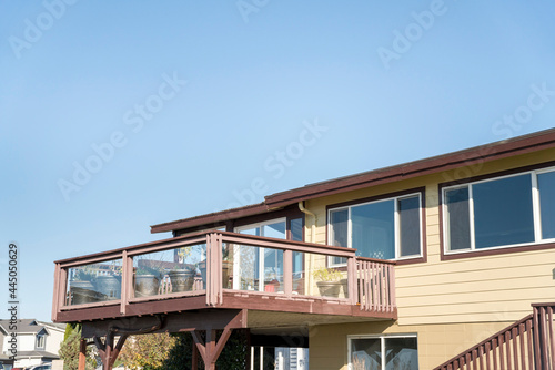 Terrace of a house with wooden handrails and glass panel