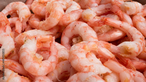 Fantastic close up of peeled fresh shrimps in a metallic bucket ready for serving.
Seafood and food preparation concept.