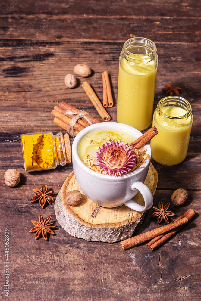 Golden turmeric milk with ice on bright yellow background Golden turmeric milk with ice on bright yellow background