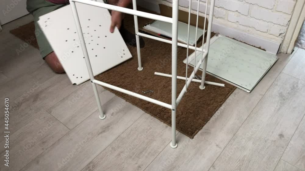 The man collects the rack. Installs a metal shelf. Homework during self-isolation. The man collects the rack. Installs a metal shelf. Homework during self-isolation.