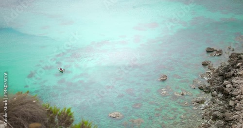 Distant View Of Kayakers In Clear Blue Ocean At The Beach Of Fomm ir-Rih In The Limits Of Mgarr, Island Of Malta. high angle, wide shot photo