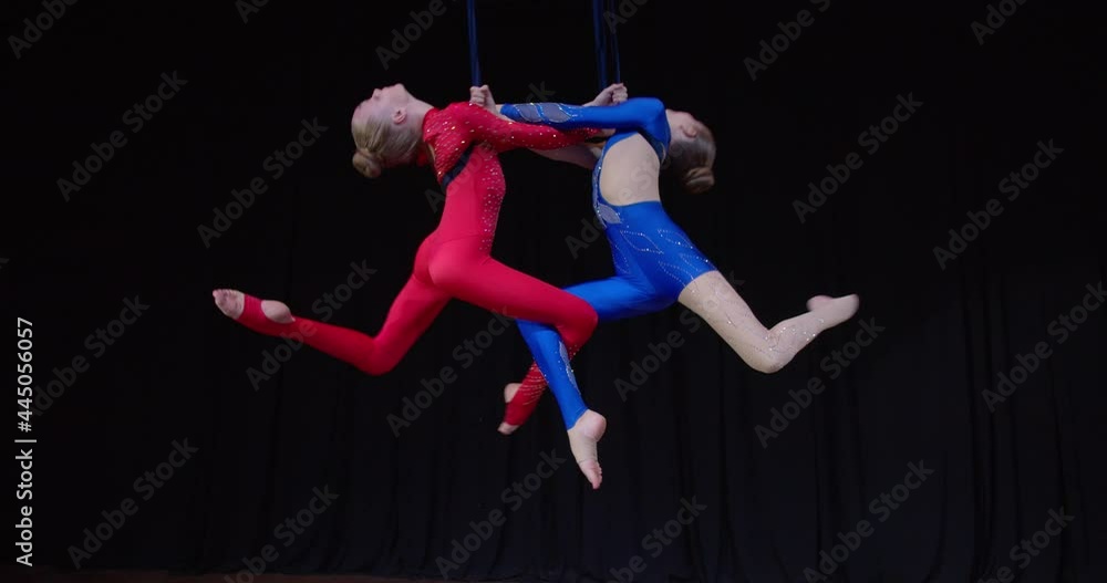 Aerial Ropes Gymnastics Skillful aerial gymnasts are performing on stage, spinning in the air ...