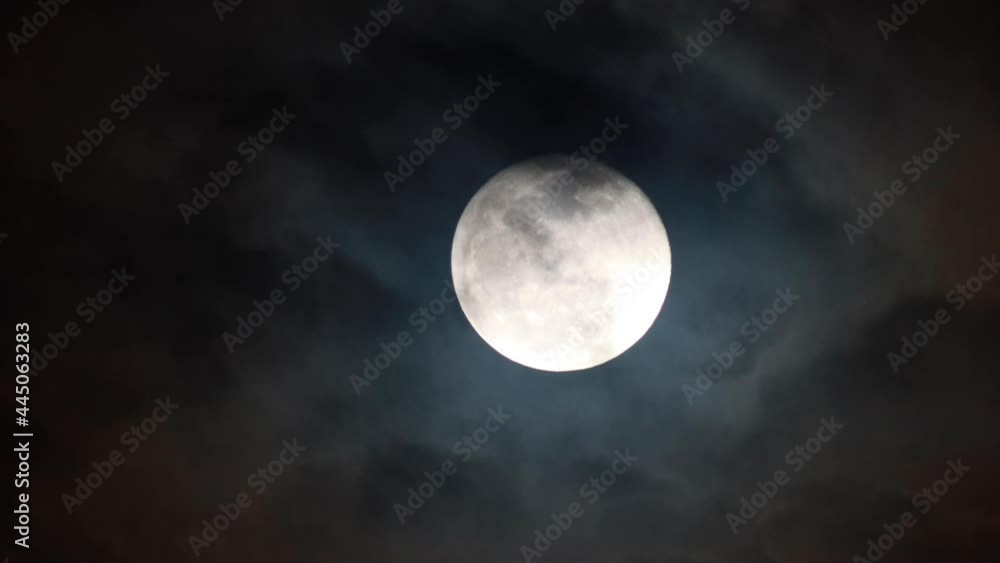 Clouds drifting across the sky. Full moon in the background Clouds drifting across the sky. Full moon in the background