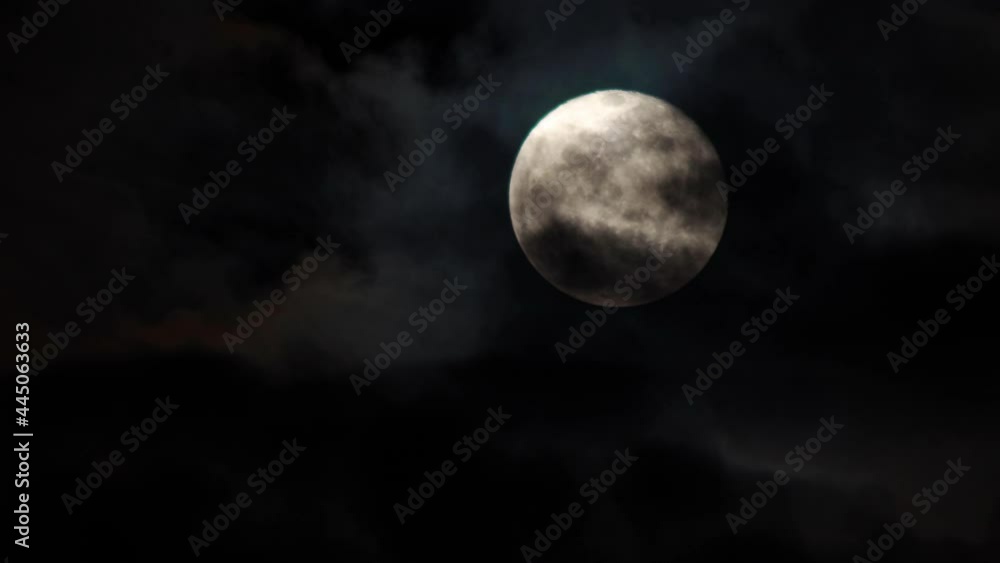 Clouds drifting across the sky. Full moon in the background Clouds drifting across the sky. Full moon in the background