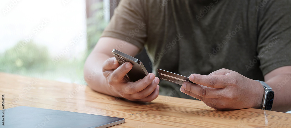 Man holding credit card and using smartphone at home, businessman shopping online, e-commerce, internet banking, spending money, working from home concept