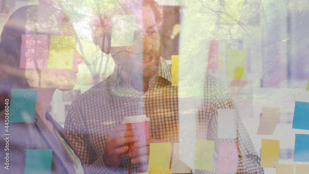 Animation of glowing light over man and woman talking in office with coffee Animation of glowing light over man and woman talking in office with coffee