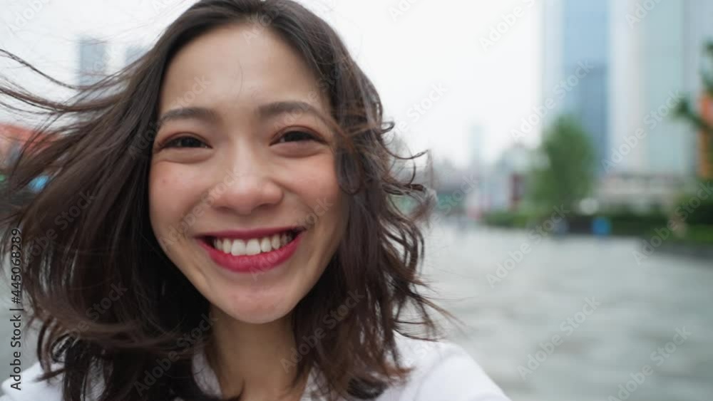 happy young asian woman close up portrait slow motion charming Chineses lady lovley girlfriend looking at camera smile in the urban city street happy young asian woman close up portrait slow motion charming Chineses lady lovley girlfriend looking at camera smile in the urban city street