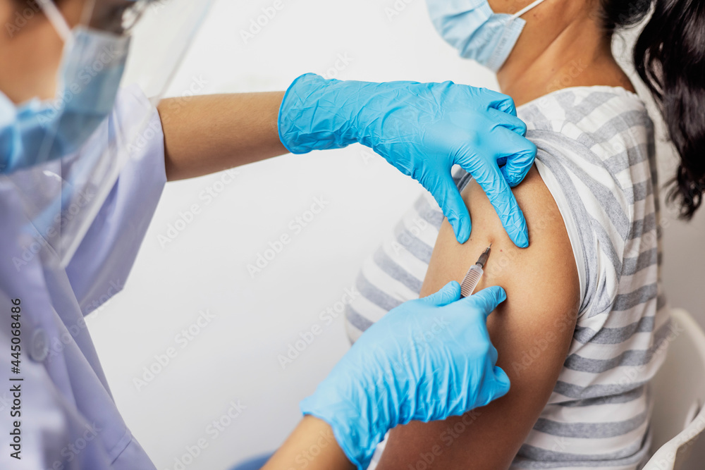 Female doctor giving shot vaccine patient shoulder. Vaccination prevention virus covid19 pandemic. Female doctor giving shot vaccine patient shoulder. Vaccination prevention virus covid19 pandemic.