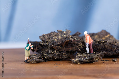 Miniature workers dividing black brick tea photo