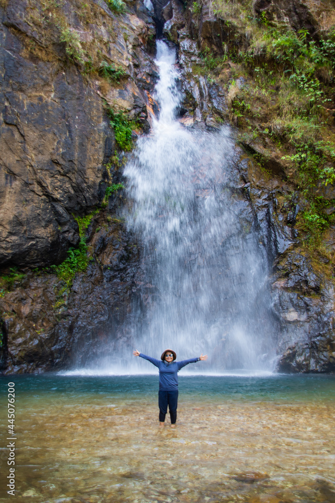 waman stand in front of beautiful waterfall name's Jok ka din in Kanchanaburi province, Thailand. subject is blurred. waman stand in front of beautiful waterfall name's Jok ka din in Kanchanaburi province, Thailand. subject is blurred.