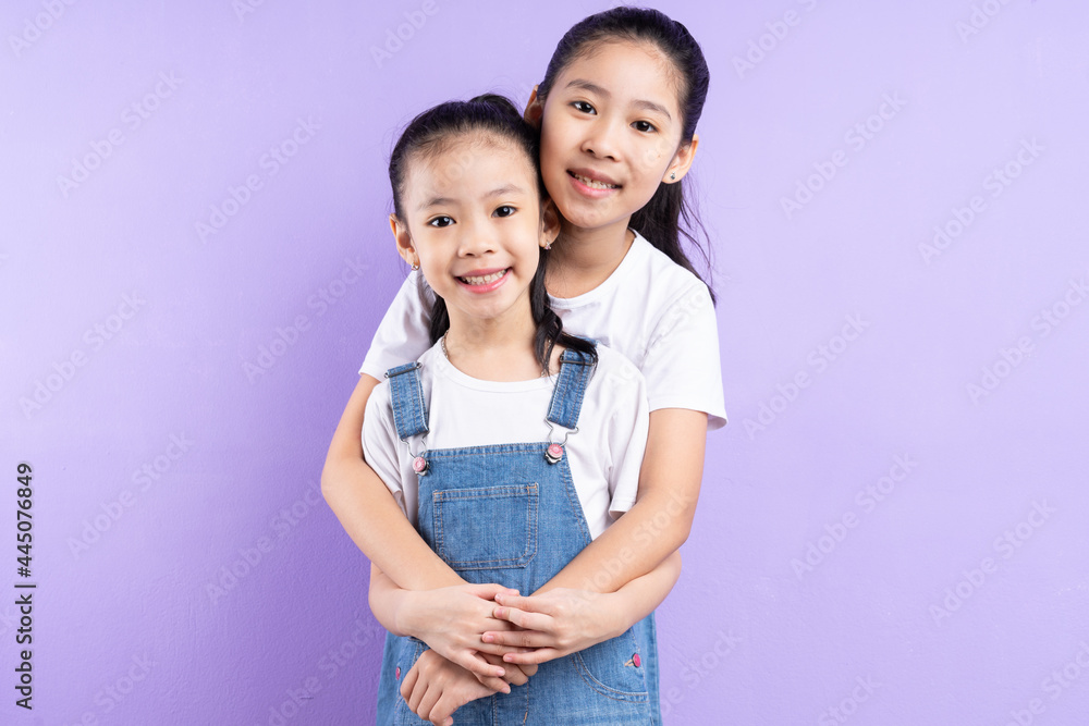 Portrait of two Asian girls on purple background Portrait of two Asian girls on purple background