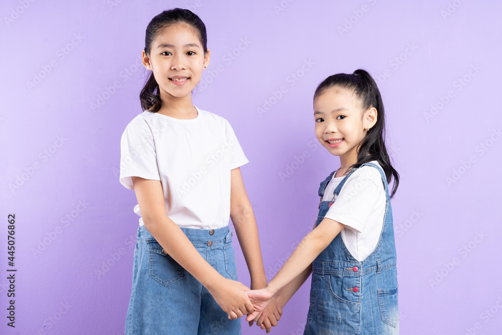 Portrait of two Asian girls on purple background Portrait of two Asian girls on purple background