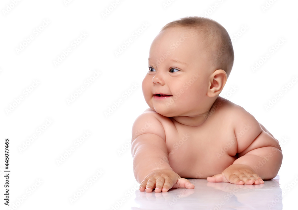 Smiling, giggling playful infant child baby girl kid in diaper is lying on her tummy holding arm outstretched, slapping on floor, looking aside isolated on a white background Smiling, giggling playful infant child baby girl kid in diaper is lying on her tummy holding arm outstretched, slapping on floor, looking aside isolated on a white background