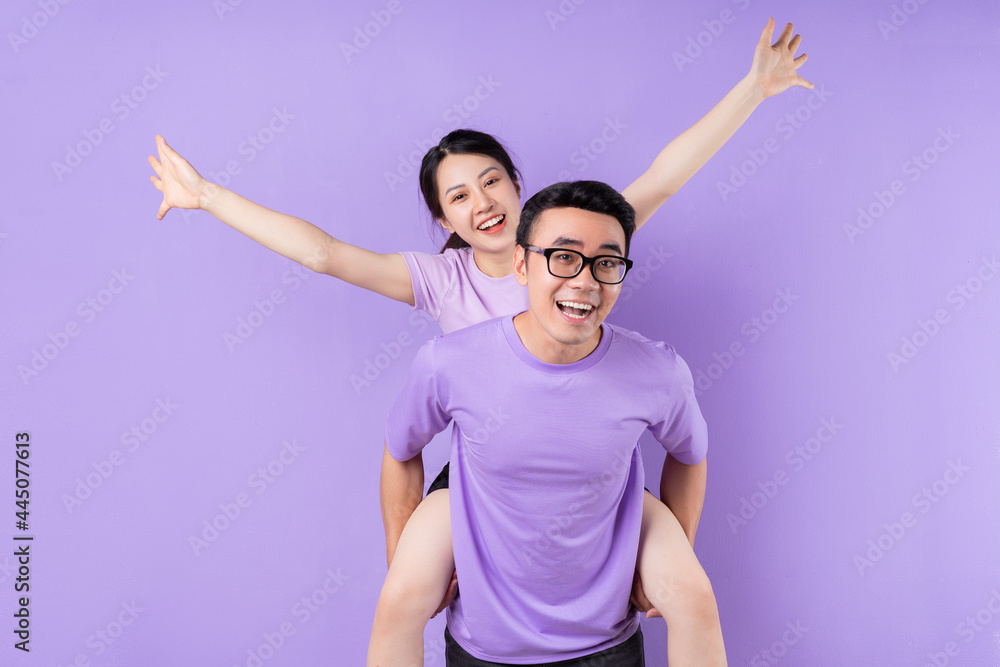 Obraz premium Young Asian couple posing on purple background