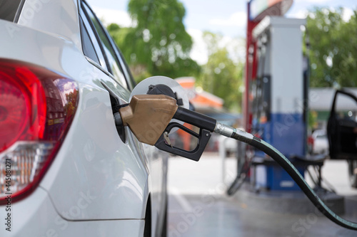 Closeup of woman pumping gasoline fuel in car at gas station. Petrol or gasoline being pumped into a motor vehicle car..