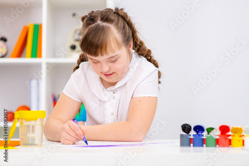 Beautiful girl with Down Syndrome works at home