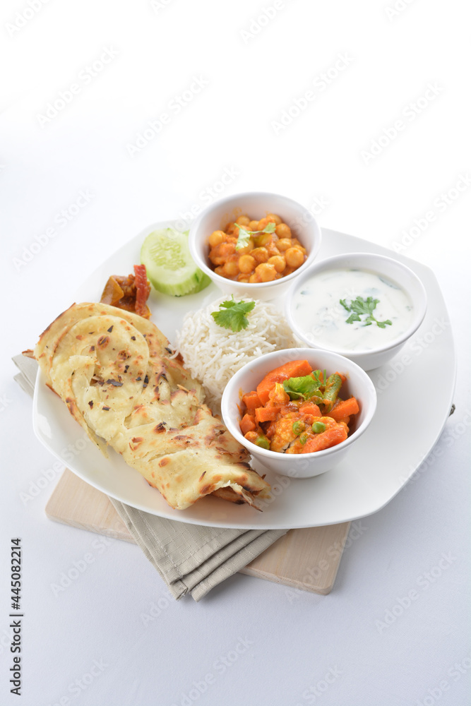 Indian baked roti prata canai with curry vegetables, yogurt sauce, pea bean and steamed white rice in white background asian vegan halal menu