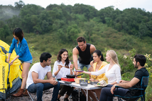 group of young friends camping and having fun while preparing food. adventure camping concept
