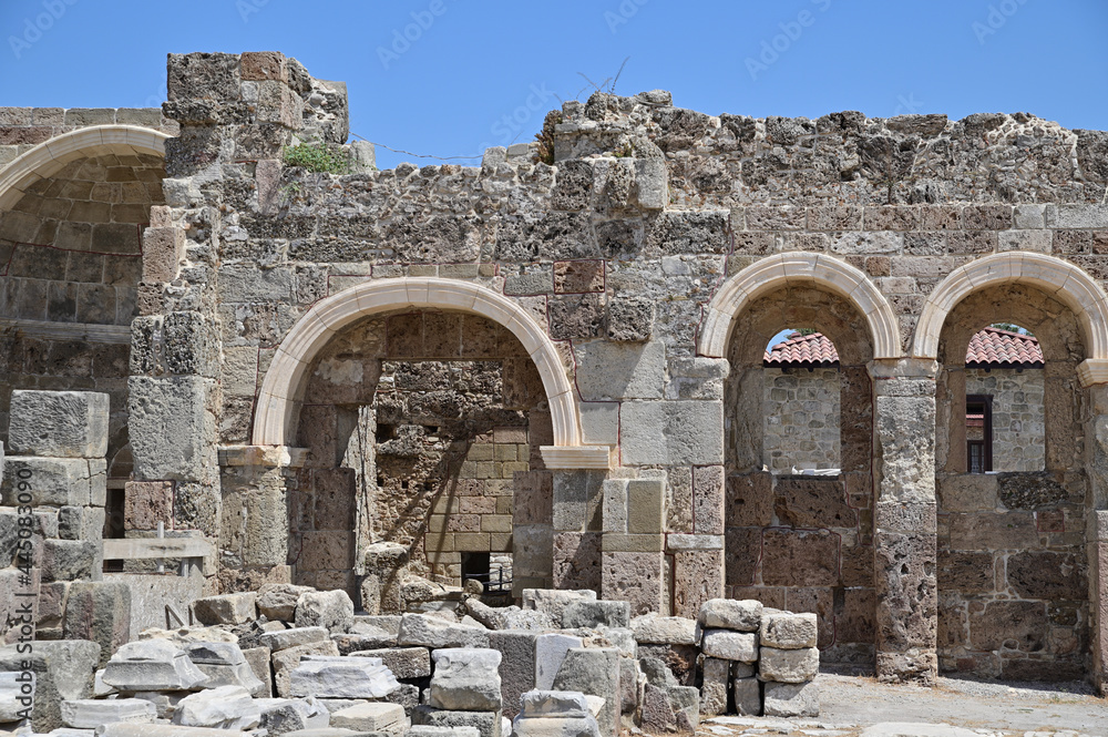 Ruins of an ancient Roman building made of hewn stones with arched doors and windows