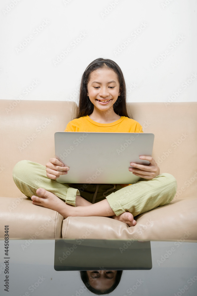 Asian little girl with laptop attending to online school class at home Asian little girl with laptop attending to online school class at home