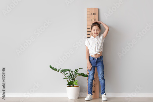Little girl measuring heigh...