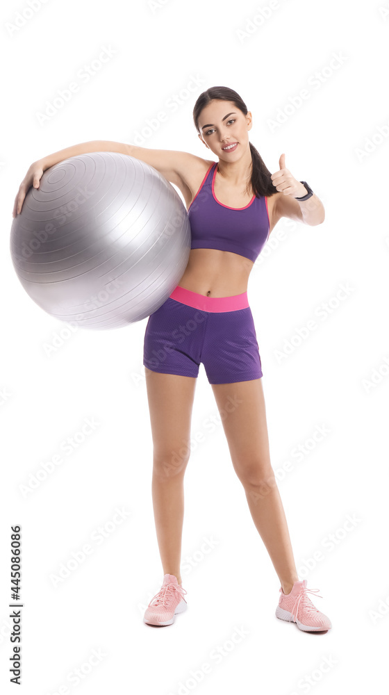 Sporty female coach with fitball showing thumb-up on white background Sporty female coach with fitball showing thumb-up on white background