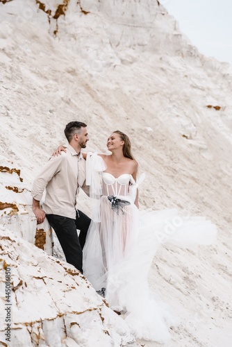 Beautiful wedding couple bride and groom at wedding day outdoors at ocean beach. Happy marriage couple o