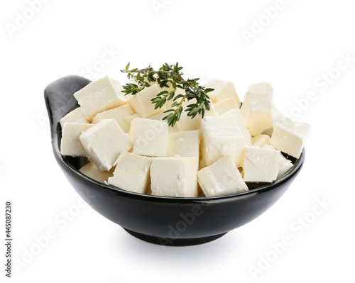 Bowl with pieces of feta cheese and thyme on white background
