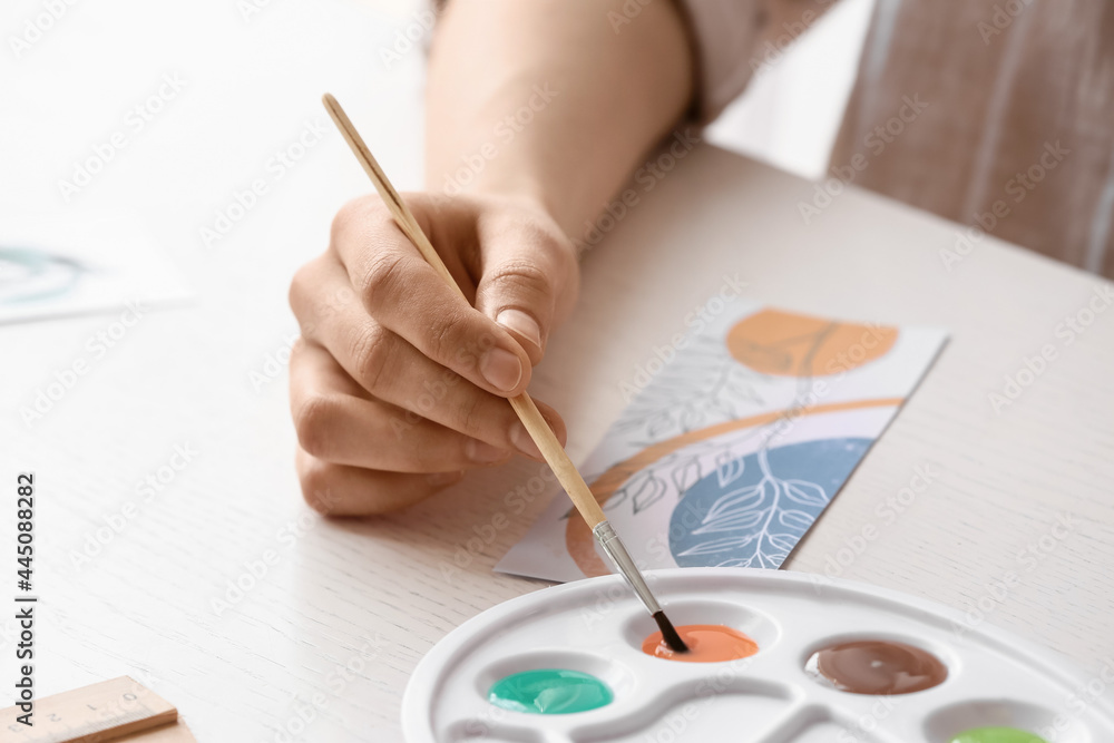 Woman drawing on bookmark at table, closeup Woman drawing on bookmark at table, closeup
