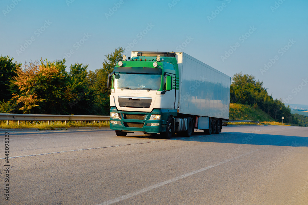 Arriving truck on the road in a rural landscape at sunset Arriving truck on the road in a rural landscape at sunset