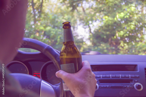 Foto The driver of the car holds a bottle of beer while driving