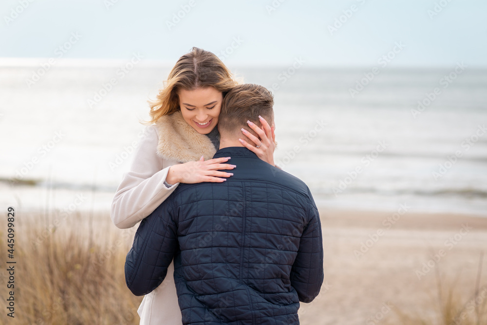 young beautiful stylish couple in spring on the beach. Hug each other and enjoy a warm spring evening.Close up.