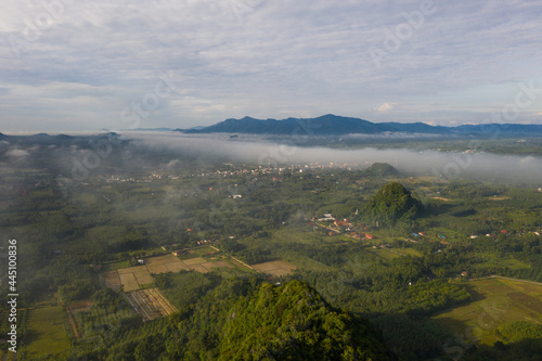 Panorama Aerial view Drone shot of Beautiful scenery landscape sunlight in the morning sunrise above flowing fog waves on mountain peak 