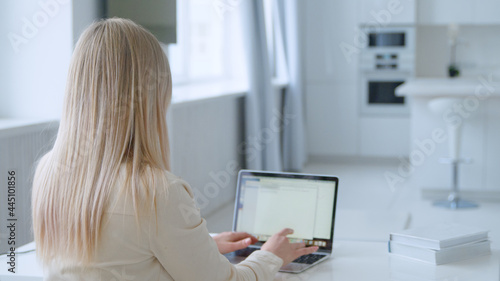 Young woman typing on laptop at the desk