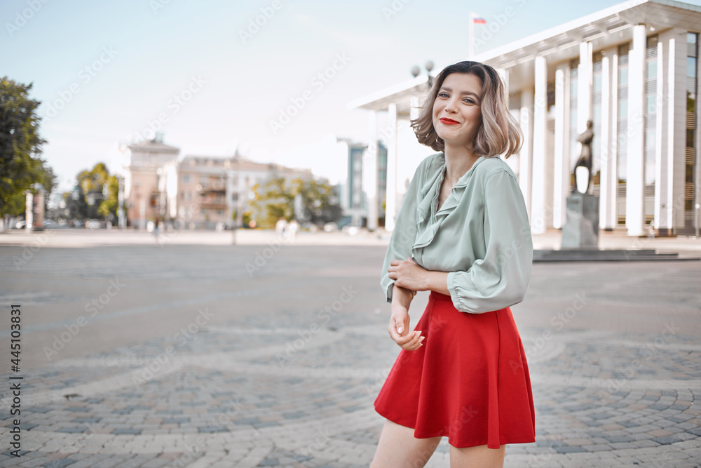 blonde in red skirt outdoors walking outdoors posing