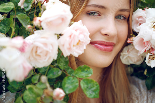 Beautiful young woman smells a rose flower. High quality photo