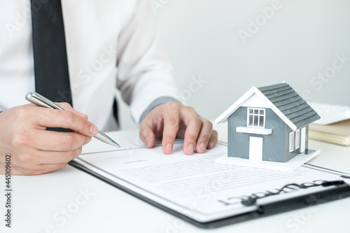 Agents working in real estate investment and home insurance signing contracts in accordance with the home buying insurance agreements approving purchases for clients