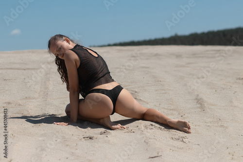 Foto Graceful woman in bikini on sandy beach