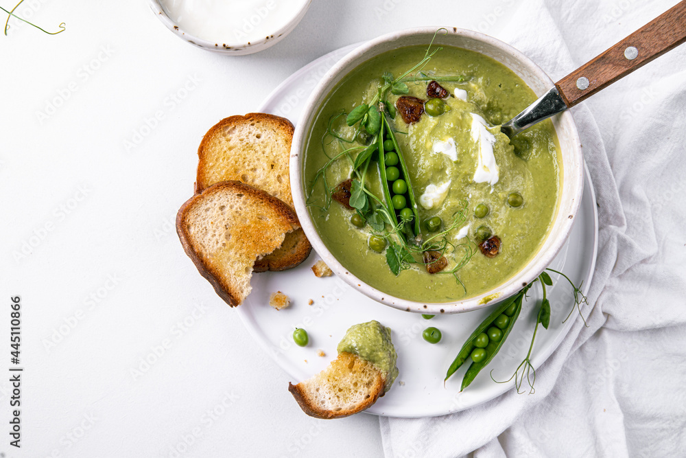 Cream of green peas soup with toasts and sour cream.