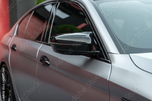 Fototapeta Naklejka Na Ścianę i Meble -  Front side view of the metallic color modern sports car close up. Rearview mirror and doors. Exterior detail.