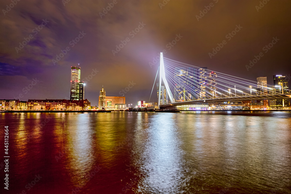 Netherlands Travel Concepts. Tranquil Night View of Renowned Erasmusbrug (Swan Bridge) in Rotterdam in Front of Port with Harbour. Shoot Made At Dusk. Netherlands Travel Concepts. Tranquil Night View of Renowned Erasmusbrug (Swan Bridge) in Rotterdam in Front of Port with Harbour. Shoot Made At Dusk.