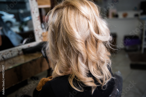 Blond hair with curls, current trend, of a client in the hairdressing salon
