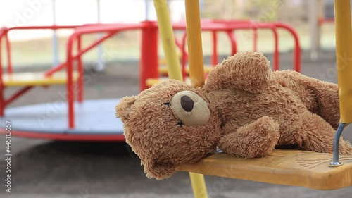 Forgotten Bear on a Childrens Swing in an Empty Playground. Concept Childhood, Psychology, Foster Child, Kindergarten, Orphanage