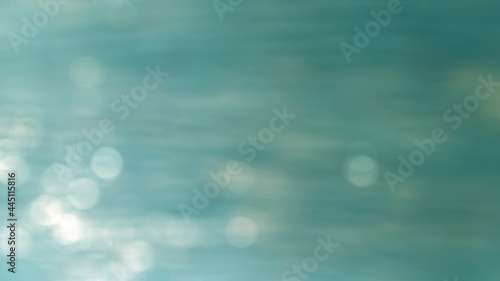 Abstract blur image background of sea blue, with sunlight bokeh, concept bokeh nature, space for the text, suitable for a background, design style..
